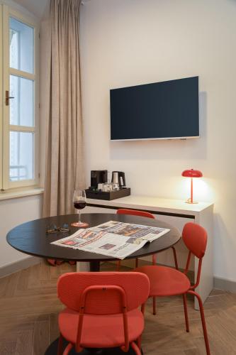 a living room with a table and two red chairs at PIAC Luxury Suites in Split
