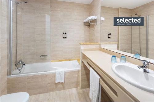 a bathroom with a tub and a sink and a shower at Garden Playanatural - Adults Only in El Rompido