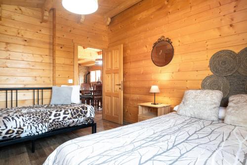 1 dormitorio con paredes de madera, cama y espejo en La Cabaña en Vejer, en Vejer de la Frontera