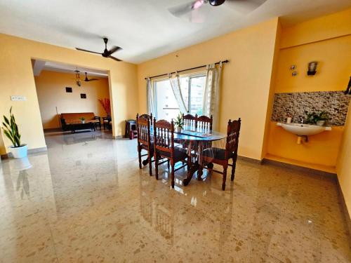 a dining room with a table and chairs and a sink at Amity landmark in Alwaye