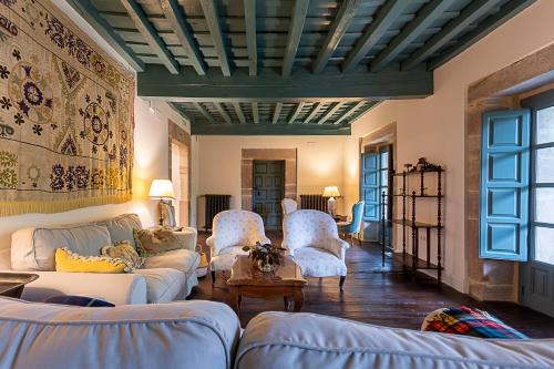 a living room with a couch and chairs and a ceiling at Hotel Casa Luca de Tena in Sopeña