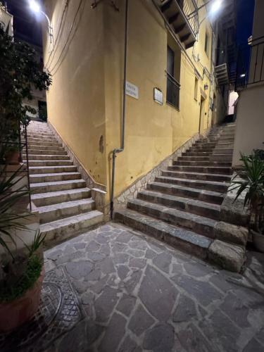 an alley with stairs in a building at night at Le Scalette del centro in Agrigento