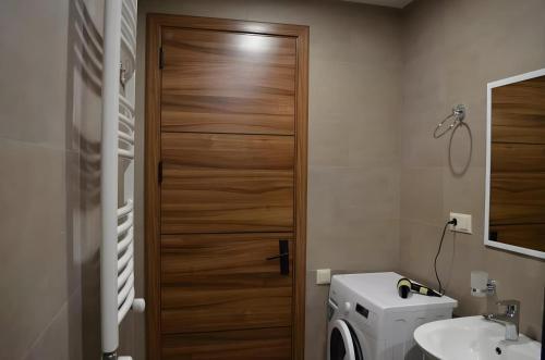 a bathroom with a toilet and a wooden door at Area Park Bakuriani, Apartment 5 in Bakuriani