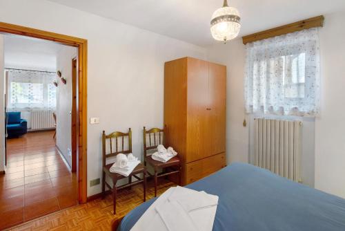 a bedroom with a bed and a table and chairs at Appartamenti Minotto Falcade in Falcade