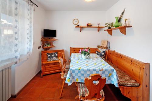 a dining room with a table and chairs and a television at Appartamenti Minotto Falcade in Falcade