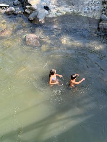 two women are swimming in a body of water at A villa in nature in Sindietʼi
