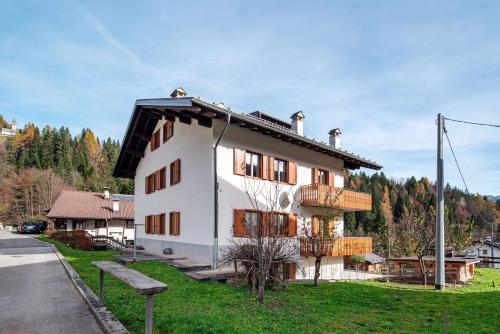 a white house with a black roof at Appartamenti Minotto Falcade in Falcade