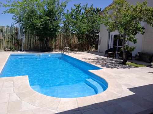 a swimming pool with blue water in a yard at PATO BLANCO in Ciudad Lujan de Cuyo