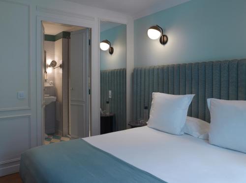 a bedroom with a large bed with white pillows at Hotel Bachaumont in Paris