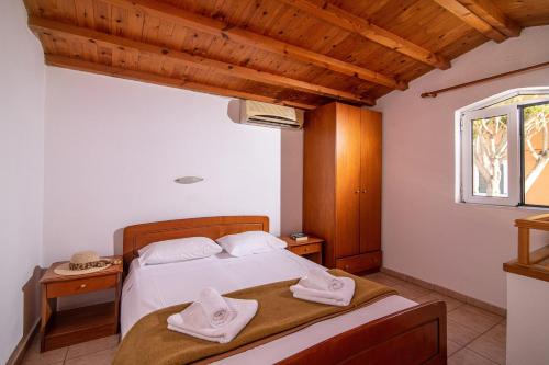 a bedroom with a bed with towels on it at Golden Valentin Apartments in Hersonissos