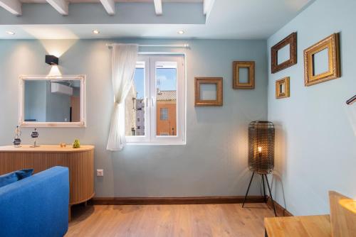 un salon avec un canapé bleu et une fenêtre dans l'établissement Campiello Urban Nest by Corfuescapes, à Corfu