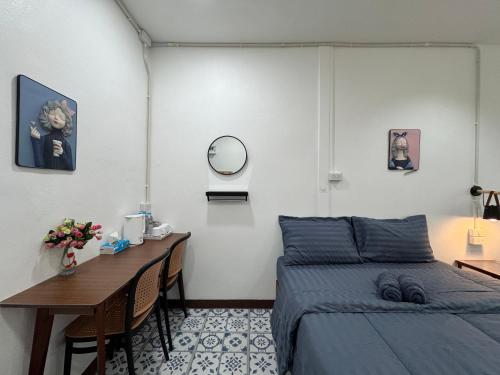 a bedroom with a bed and a table and a mirror at Nut Home Hostel in Ban Ko