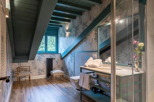 a blue bathroom with a sink and a mirror at Hotel Casa Luca de Tena in Sopeña