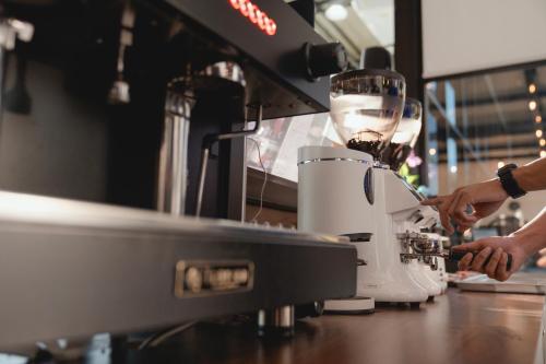 a person is preparing a drink in a coffee machine at Baan Plaifah Khao Yai Hotel in Khao Yai