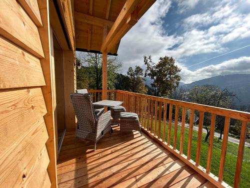 a porch with two chairs and a table on it at Nock Chalets in Afritz