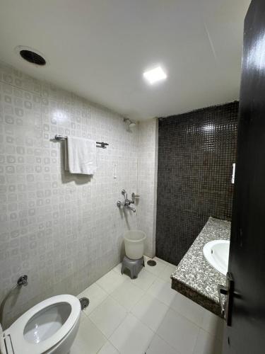 a bathroom with a toilet and a sink at Hotel Chandigarh Grand and Banquet in Manī Mājra