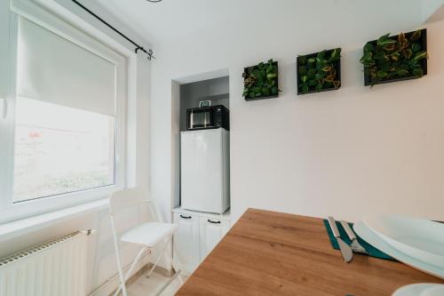 una cocina con una mesa y un refrigerador en Fanni Apartment, en Odorheiu Secuiesc