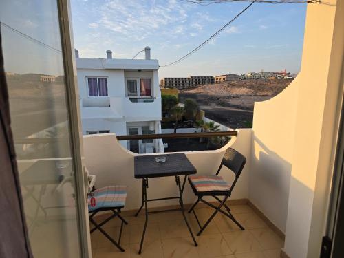 a small balcony with a table and chairs on it at Ocean's Dream Fuerteventura in Antigua