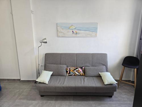 a couch in a living room with a painting on the wall at Ocean's Dream Fuerteventura in Antigua