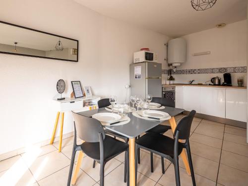 une salle à manger avec une table et des chaises et une cuisine dans l'établissement Appartement Chaleureux avec 2 grandes chambres, à Saint-Rambert-dʼAlbon