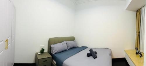 a bedroom with a bed with a black bow tie on it at R&F Princess Cove View Residences by WSD in Johor Bahru