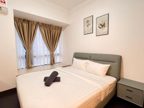 a bedroom with a bed with a black hat on it at R&F Princess Cove View Residences by WSD in Johor Bahru