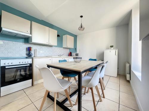 - une cuisine avec une table en bois et des chaises blanches dans l'établissement Le Havre des Ecoles - 2chambres-Rez de jardin et Parking-BBQ, à Saint-Rambert-dʼAlbon