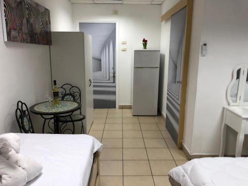 a small room with a table and a small kitchen at Sea Line Hotel From R&A Group in Bat Yam