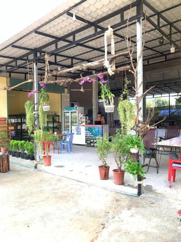 a patio with potted plants and tables and chairs at Top View Kohrong in Koh Rong