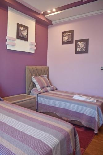 two beds in a room with purple walls at Abraj Dubai 3 bedroom luxury apartment in Larache