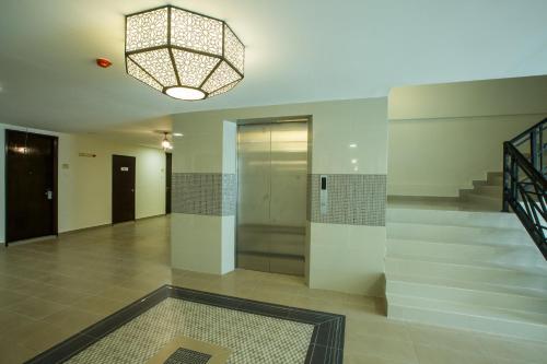 a lobby with a elevator and a chandelier at Humaira Hotel in Tanah Merah