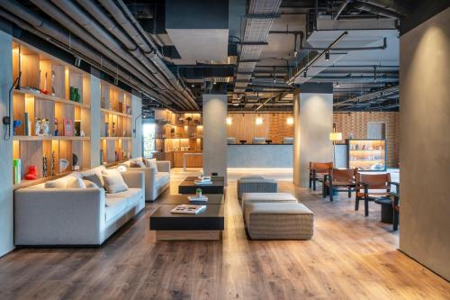 a living room with couches and tables and chairs at INNSiDE by Meliá Madrid Valdebebas in Madrid