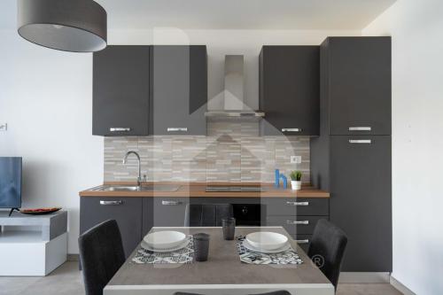 Una cocina con una mesa con sillas y un fregadero. en Homiday - WaterFront Montesilvano, en Montesilvano
