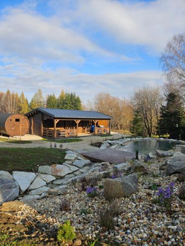 a log cabin with a pond in front of it at Horský apartmán MIKI in Filipovice