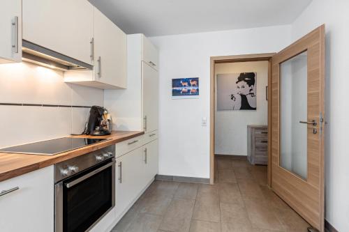 a kitchen with white cabinets and a counter top at Ferienwohnung Sägegasse, Typ A in Münstertal