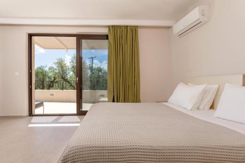 a bedroom with a bed and a large window at Evylio Stone Houses in Lithakia