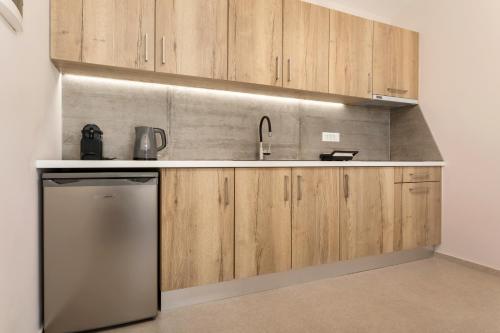a kitchen with wooden cabinets and a sink at Evylio Stone Houses in Lithakia