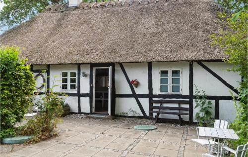 a cottage with a thatched roof and a patio at Stunning Home In Stokkemarke With Wifi in Stokkemarke