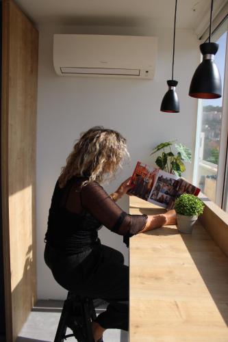 a woman sitting at a counter in a kitchen at Hostel Petra Marina in Dubrovnik