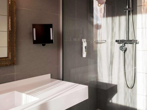 une salle de bain avec une douche avec un lavabo et un miroir dans l'établissement Mercure Lyon Centre - Gare Part Dieu, à Lyon