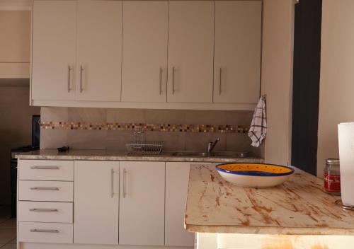 a kitchen with white cabinets and a bowl on a counter at Fossil Hills in McGregor