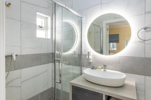 a bathroom with a sink and a shower with a mirror at Ta'Battista B&B with pool - Gozo in Xewkija