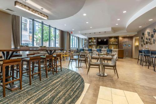 a restaurant with tables and chairs and a bar at Cambria Hotel Rockville in Rockville