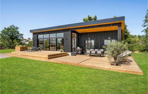 a black house with a wooden deck in a yard at Beach Front Home In Haderslev in Haderslev
