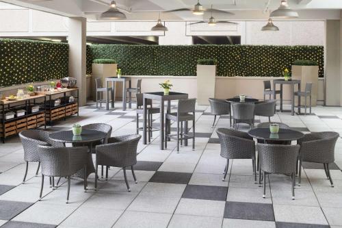 a restaurant with tables and chairs and a bar at Cambria Hotel White Plains - Downtown in White Plains