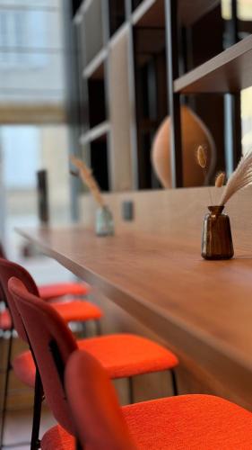 a wooden table with red chairs in a room at Campanile La Roche Sur Yon Centre Gare in La Roche-sur-Yon