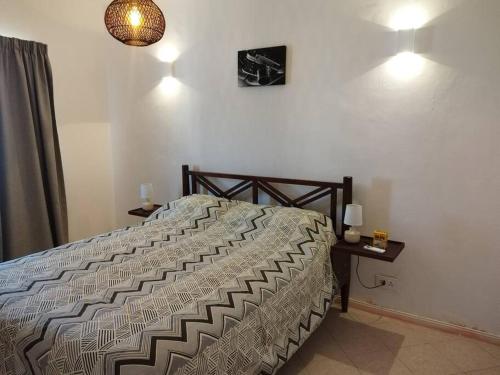 una camera da letto con un letto e un tavolo con una lampada di Welcome Aboard Villa a Flic-en-Flac