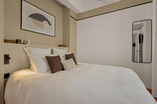 une chambre avec un grand lit blanc avec des oreillers dans l'établissement Exceptionnel face Palais Cannes, à Cannes