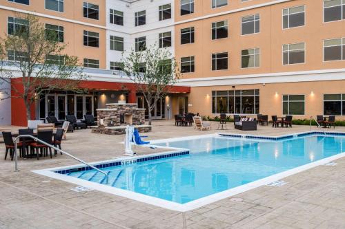 a swimming pool in front of a building with a hotel at Cambria Hotel McAllen Convention Center in McAllen