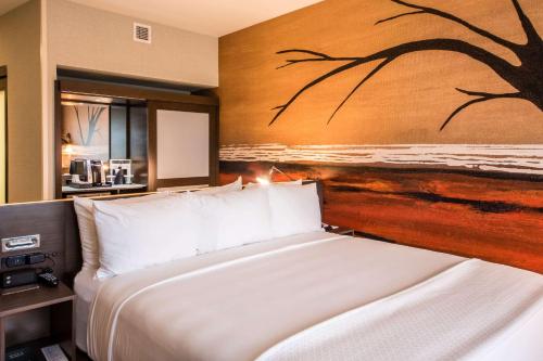 a bedroom with a bed with a painting on the wall at Cambria Hotel McAllen Convention Center in McAllen